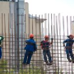 4 steel workers working above ground on rebar frames, safety comes first
